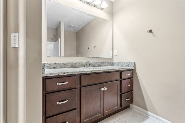 full bath with a shower, tile patterned flooring, vanity, and baseboards