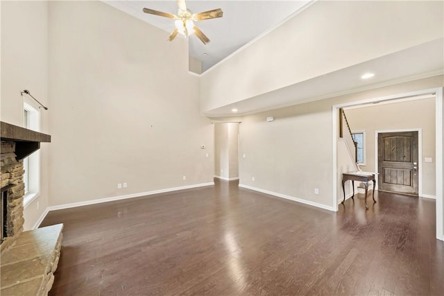 2133 W Farmville Rd W, Auburn, AL 36879 - unfurnished living room featuring a fireplace, ceiling fan, baseboards, a towering ceiling, and dark wood finished floors