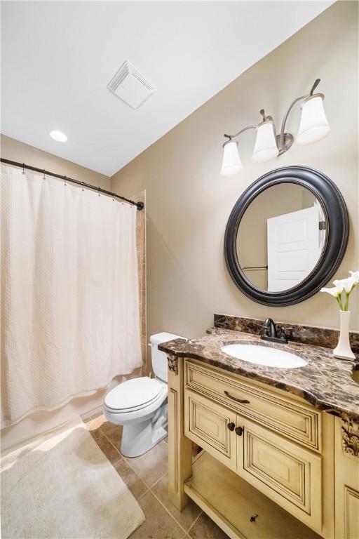 bathroom featuring vanity, curtained shower, tile patterned floors, and toilet