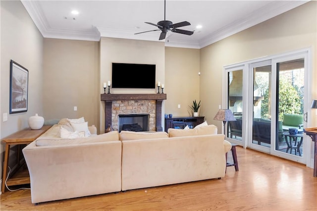 living room featuring crown molding, ceiling fan, a fireplace, and light hardwood / wood-style floors