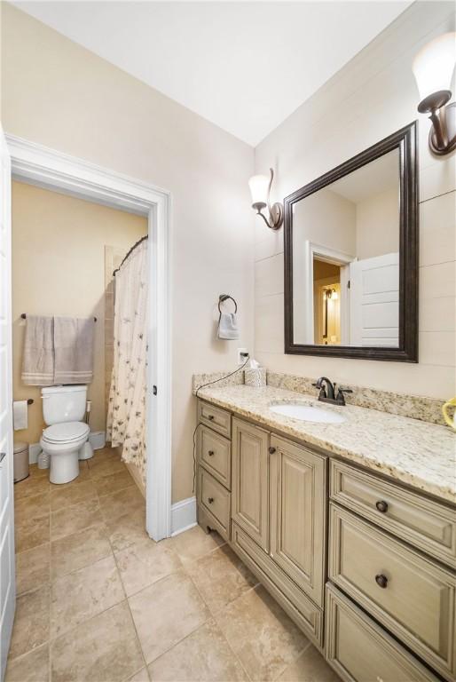 bathroom with walk in shower, tile patterned floors, vanity, and toilet