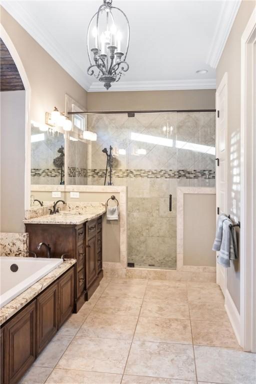 bathroom featuring ornamental molding, separate shower and tub, vanity, and a chandelier