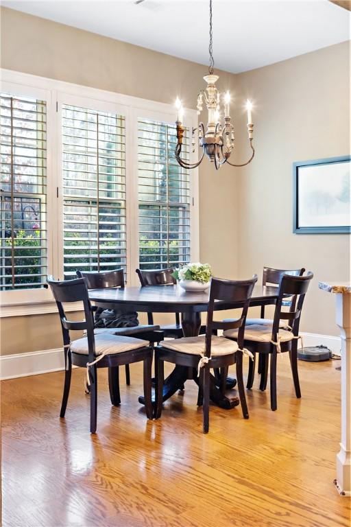 dining area with a notable chandelier and light hardwood / wood-style floors