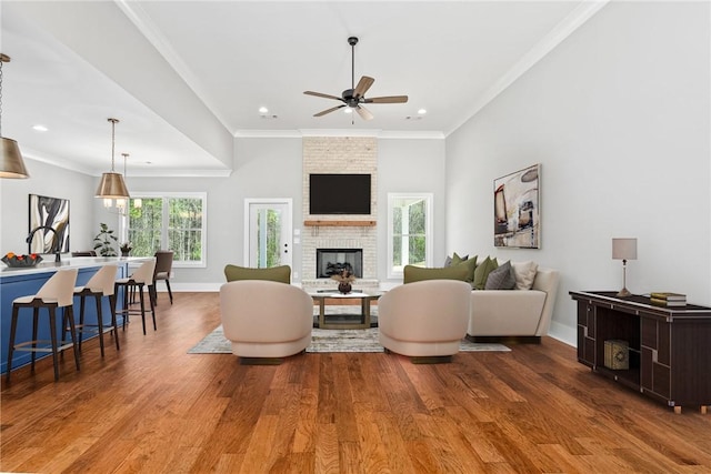 3667 Tiana Way, Opelika, AL 36801 - living area featuring wood finished floors, a ceiling fan, crown molding, a brick fireplace, and baseboards