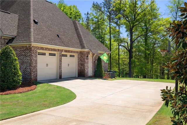 1321 Falls Crest Dr, Auburn, AL 36830 - view of home's exterior with a garage, a lawn, brick siding, a shingled roof, and driveway