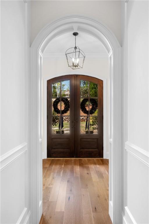 1321 Falls Crest Dr, Auburn, AL 36830 - doorway with a chandelier, arched walkways, light wood-style floors, and french doors