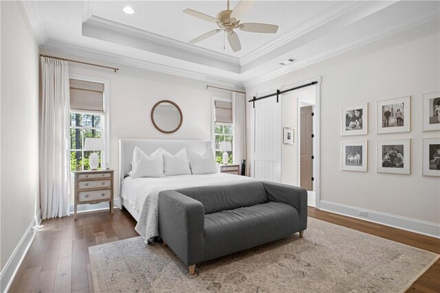 1321 Falls Crest Dr, Auburn, AL 36830 - bedroom featuring a raised ceiling, wood finished floors, baseboards, and a barn door