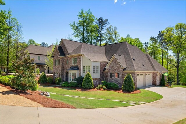 1321 Falls Crest Dr, Auburn, AL 36830 - view of front of house featuring a front yard, a shingled roof, an attached garage, brick siding, and driveway