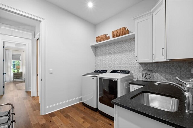 1321 Falls Crest Dr, Auburn, AL 36830 - laundry room with baseboards, washer and dryer, a sink, wood finished floors, and cabinet space