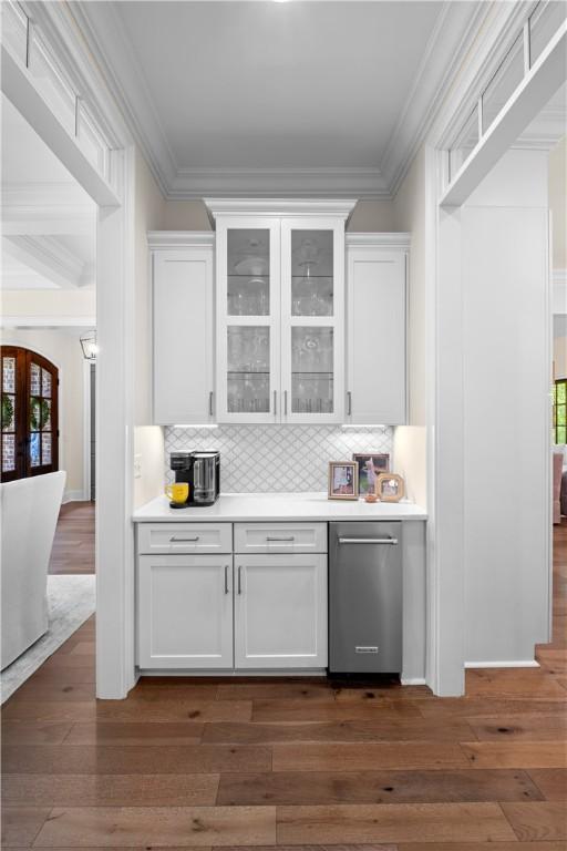 1321 Falls Crest Dr, Auburn, AL 36830 - bar featuring crown molding, tasteful backsplash, and dark wood-style floors