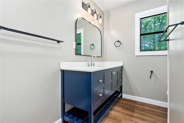 bathroom featuring baseboards, wood finished floors, and vanity