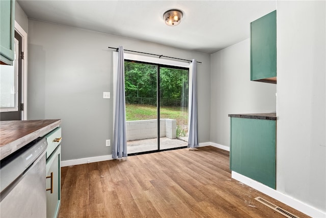 unfurnished dining area with visible vents, dark wood-style flooring, and baseboards