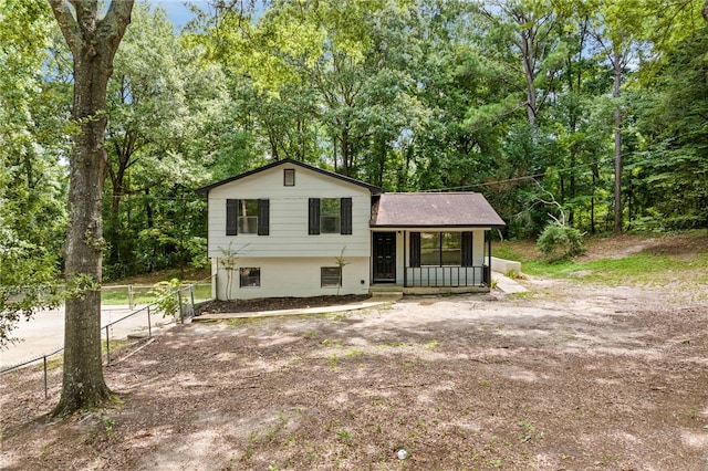 split level home featuring fence and a porch