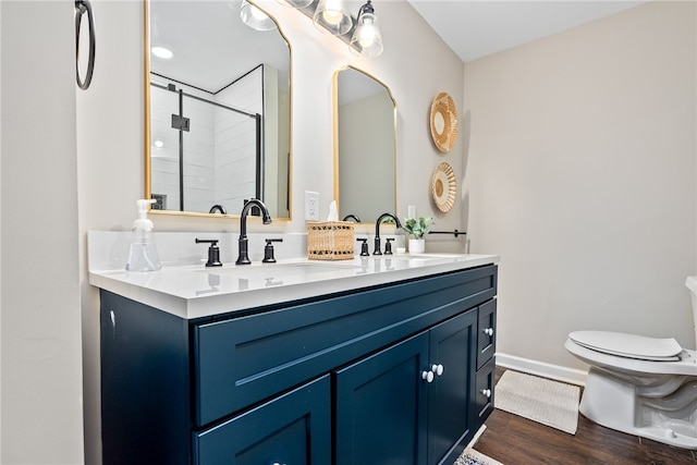 573 Hudson Ter, Auburn, AL 36830 - bathroom with double vanity, a stall shower, toilet, wood finished floors, and baseboards