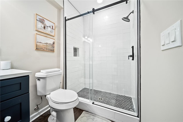 573 Hudson Ter, Auburn, AL 36830 - bathroom featuring wood finished floors, toilet, a stall shower, vanity, and baseboards