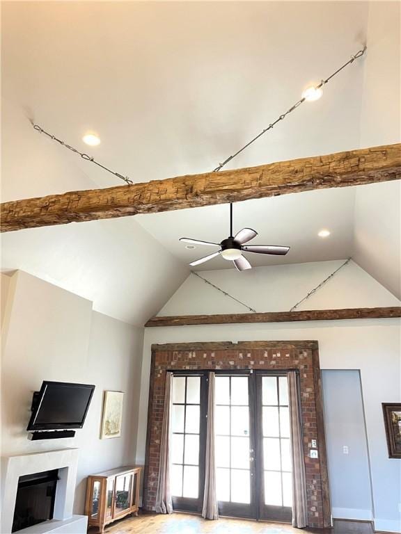 living room featuring a ceiling fan, high vaulted ceiling, a fireplace, baseboards, and beamed ceiling