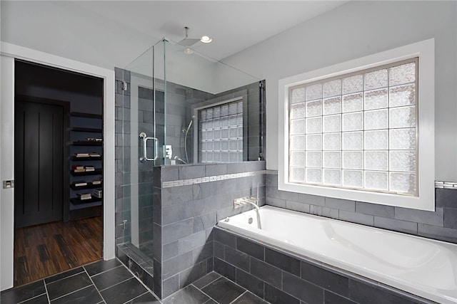 bathroom with a shower stall and a bath