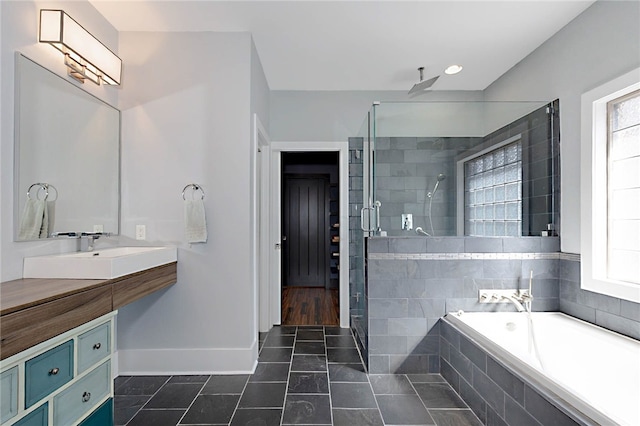 full bath with a stall shower, baseboards, a garden tub, and plenty of natural light