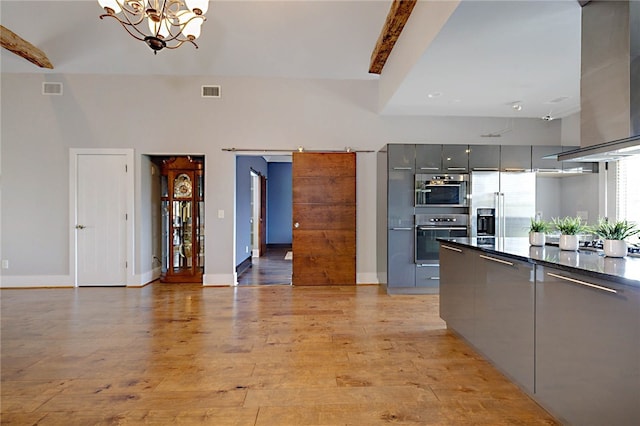 kitchen with gray cabinetry, wall chimney exhaust hood, modern cabinets, and dark countertops