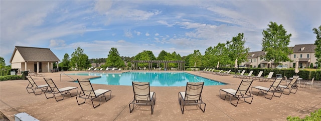 pool with a patio area, a pergola, and fence