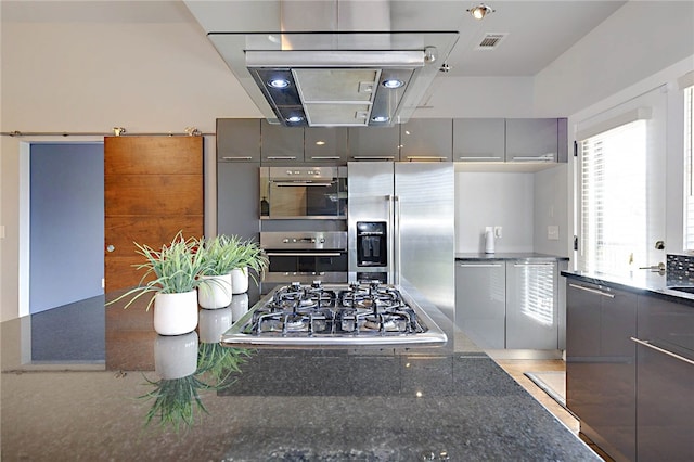 kitchen with dark stone countertops, visible vents, gray cabinetry, modern cabinets, and appliances with stainless steel finishes