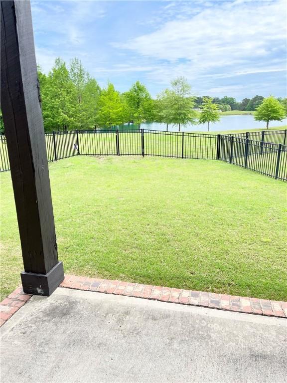 view of yard featuring a fenced backyard and a water view