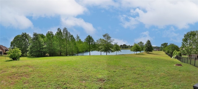 view of yard with fence and a water view