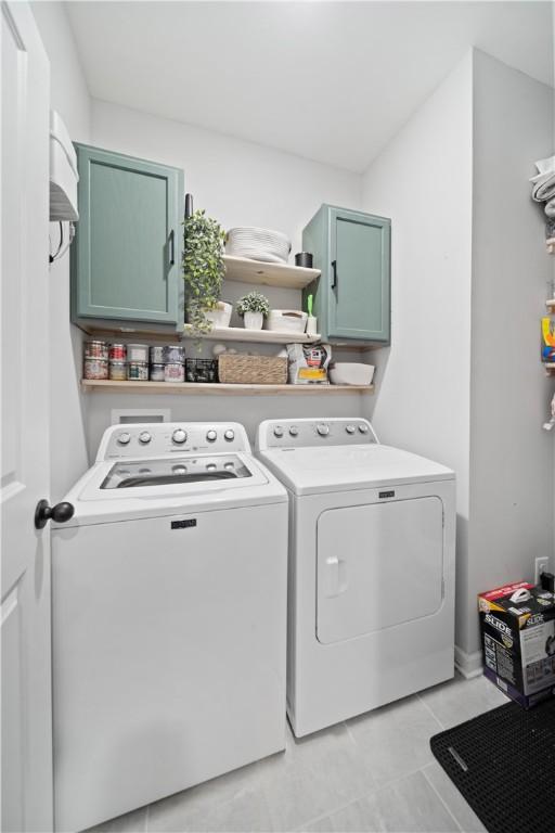 washroom featuring independent washer and dryer and cabinets