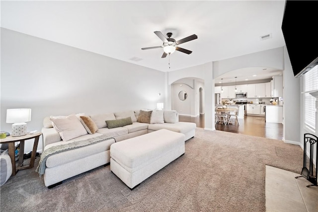 carpeted living room featuring ceiling fan