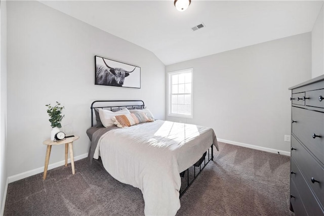 bedroom featuring lofted ceiling and dark carpet