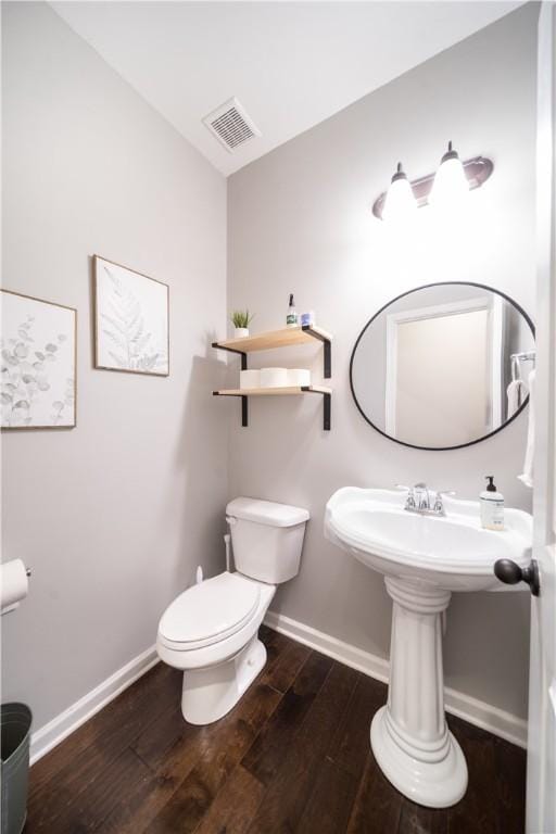 bathroom with hardwood / wood-style floors and toilet