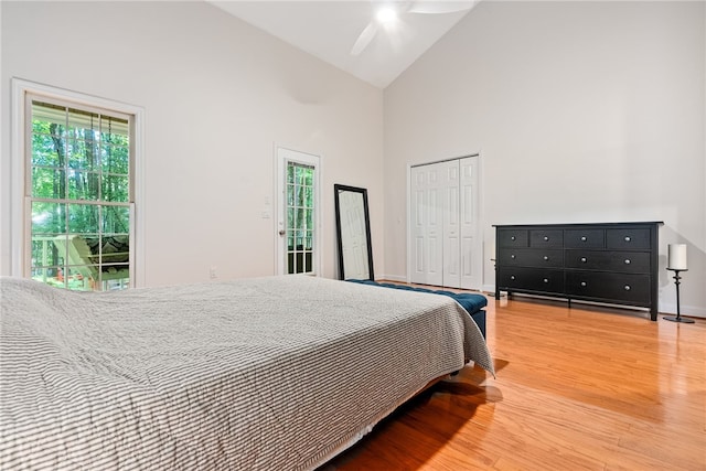 bedroom with wood-type flooring, a closet, high vaulted ceiling, and ceiling fan