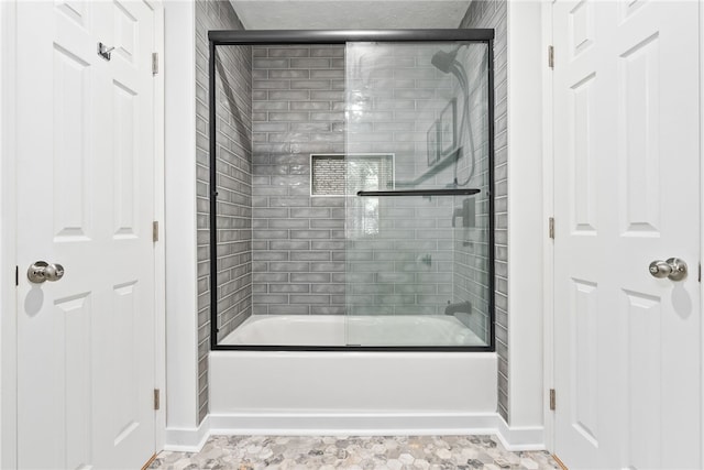 bathroom with combined bath / shower with glass door