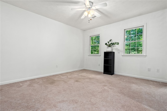 empty room featuring ceiling fan and light carpet