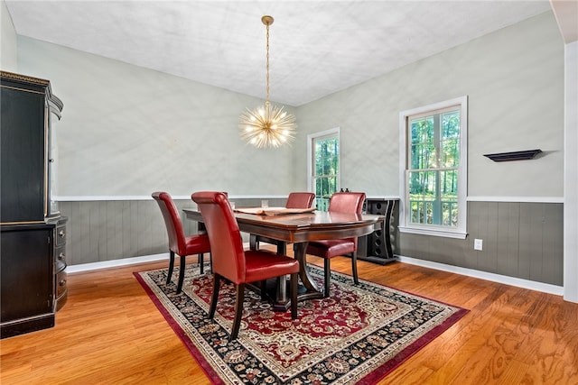 dining area with hardwood / wood-style flooring and an inviting chandelier