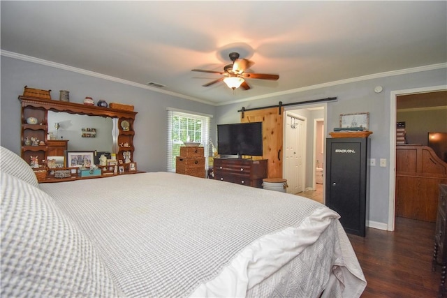 bedroom with ensuite bath, ceiling fan, a barn door, dark hardwood / wood-style floors, and ornamental molding