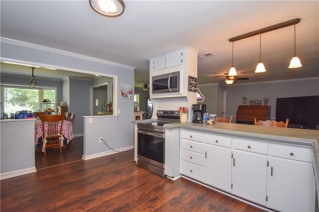 kitchen featuring white cabinets, stainless steel appliances, decorative light fixtures, and ornamental molding