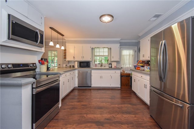 kitchen featuring a healthy amount of sunlight, white cabinets, pendant lighting, and appliances with stainless steel finishes