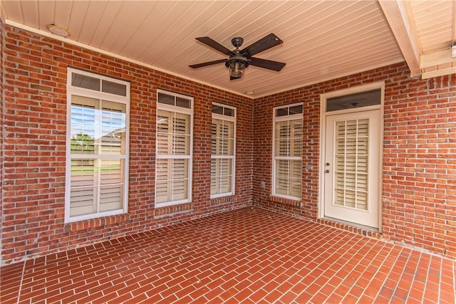 unfurnished sunroom featuring ceiling fan and wood ceiling