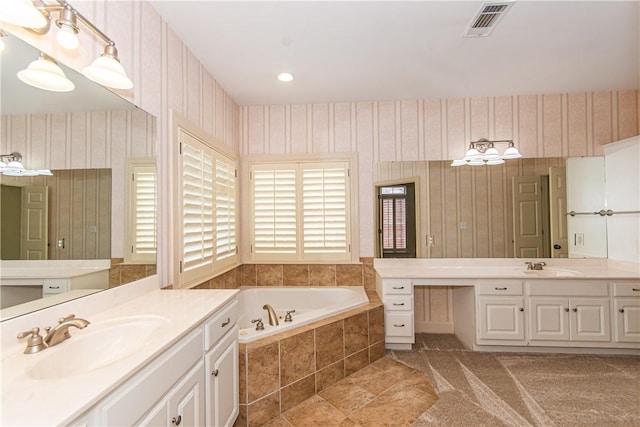 bathroom with tiled tub and vanity