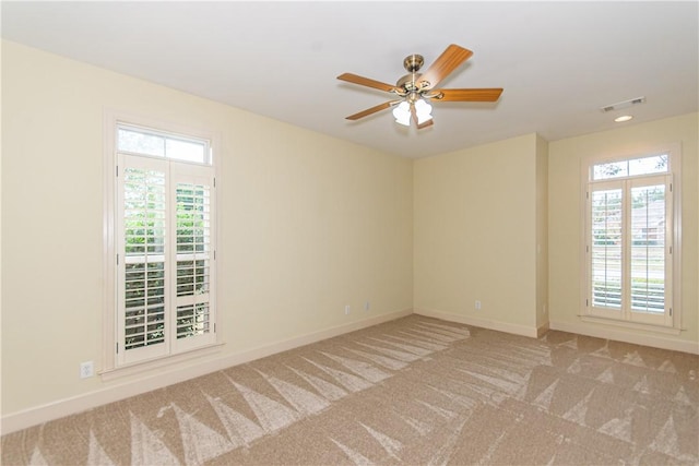 empty room with ceiling fan and light colored carpet