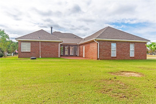 rear view of house with a lawn and a patio area