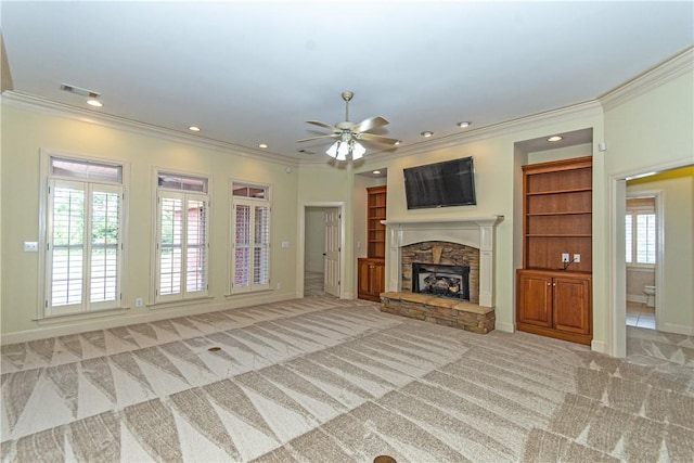 unfurnished living room featuring ceiling fan, a fireplace, light carpet, and a healthy amount of sunlight