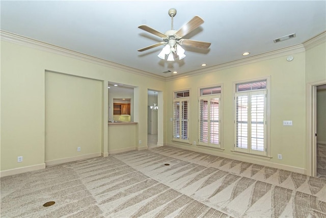 carpeted spare room with ceiling fan and crown molding