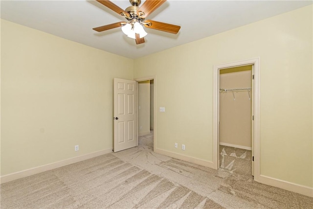 unfurnished bedroom with ceiling fan, light colored carpet, a spacious closet, and a closet