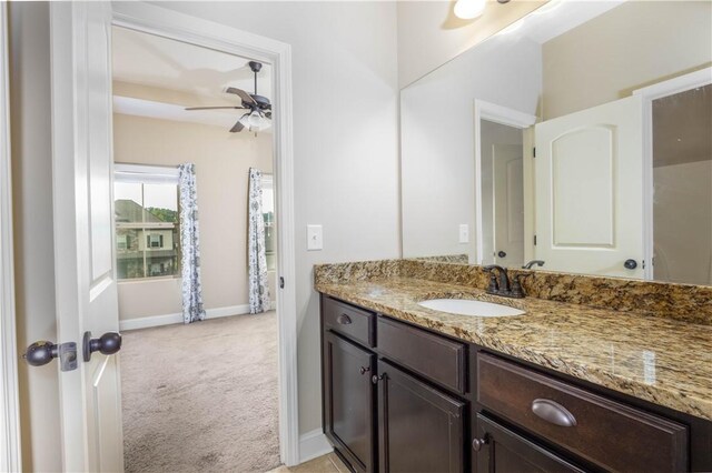 bathroom with ceiling fan, vanity, and baseboards
