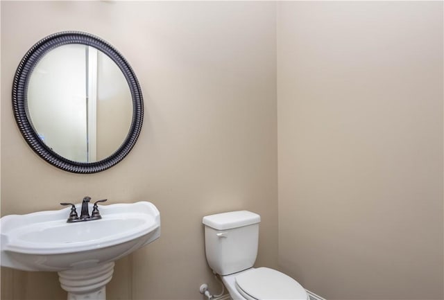 half bath with toilet and a sink