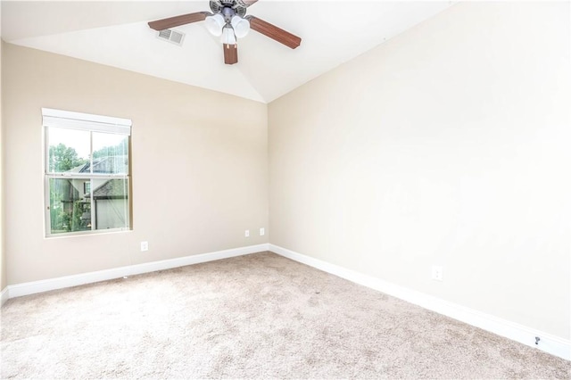 carpeted spare room featuring baseboards, a ceiling fan, and vaulted ceiling