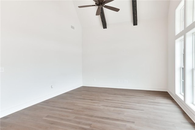 spare room with a ceiling fan, beamed ceiling, light wood-style floors, baseboards, and high vaulted ceiling