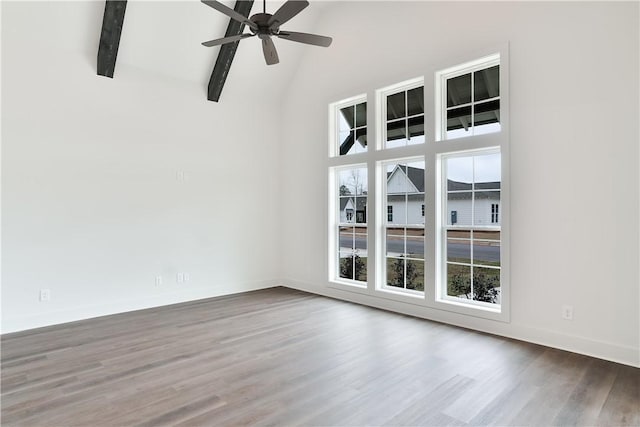 unfurnished room featuring wood finished floors, a ceiling fan, beamed ceiling, baseboards, and high vaulted ceiling